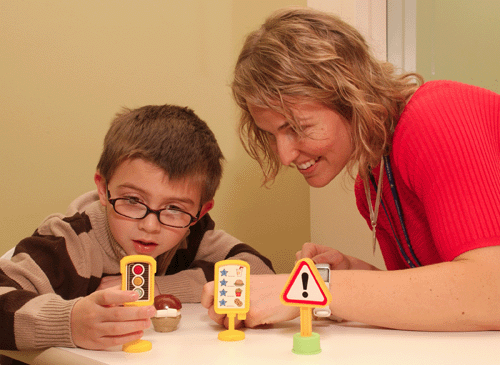 Speech-language professional engaging a child in an interactive therapy activity